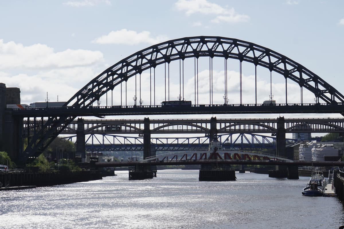 The steel arch of the Tyne Bridge over the River Tyne in Newcastle, with the Swing Bridge and High Level Bridge beyond