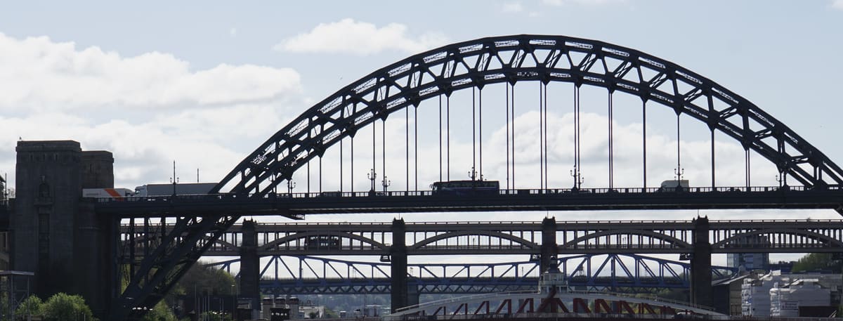 The steel arch of the Tyne Bridge over the River Tyne in Newcastle, with the Swing Bridge and High Level Bridge beyond